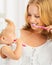 Mother and daughter baby girl brushing their teeth together