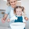 Mother and daughter baking at home. Happy mother and child bonding and cooking. Woman helping her daughter make batter