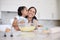 Mother and daughter baking together in a home kitchen. Caring small adorable little girl kissing her single mother on