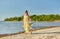 Mother and daughter with ball walking along beach