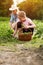 Mother and daughter with basket full of peas in garden