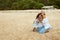 Mother And Daughter On Beach. Young Woman In Fashion Dress And Little Girl Enjoying Summer Weekend. Family Vacation.