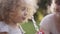 Mother and daughter blowing bubbles outdoors in summer sunshine