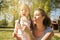 Mother and daughter blowing dandelion.