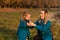 Mother and daughter blowing dandelion. Happy mother enjoying with her little daughter outdoors. Autumn fashion. Stylish mother and