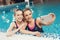 Mother and daughter at border of pool taking selfie at the gym. They look happy, fashionable and fit.