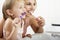 Mother And Daughter Brushing Teeth Together