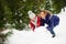 Mother with daughter build a snowman in park.