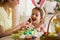 Mother and daughter celebrating Easter, eating chocolate eggs.