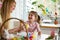 A mother and daughter celebrating Easter, painting eggs with brush