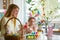 A mother and daughter celebrating Easter, painting eggs with brush