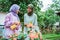 mother and daughter chatting while spraying flower plants in garden