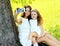 Mother and daughter child taking selfie portrait on smartphone outdoors