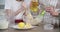 Mother and daughter child together at home kitchen kneading dough in bowl, close-up