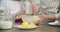 Mother and daughter child together at home kitchen kneading dough in bowl, close-up