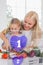 Mother and daughter chopping vegetables with purple holographic interface