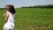 Mother and daughter are circling in a green field with a beautiful landscape.
