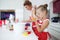 Mother and daughter cooking cupcakes into a large bright kitchen