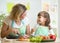 Mother and daughter cooking and cutting vegetables