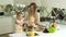 Mother With Daughter Cooking Vegetable Salad In Kitchen At Home