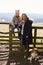 Mother and daughter by a country gate with pet dog, vertical