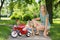Mother With Daughter Crouching By Tricycle On