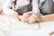 Mother and daughter cutting out different cookie shapes of dough