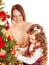 Mother with daughter decorate Christmas tree.