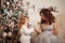 Mother and daughter decorate a Christmas tree.