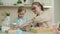 Mother and daughter decorating cupcakes in kitchen discussing food preparation at home