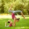 Mother and daughter doing exercise outdoors.