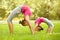 Mother and daughter doing exercise outdoors.