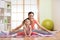 Mother and daughter doing fitness exercises on mat at home