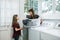 A mother and daughter doing laundry chores together in their natural light laundry room