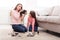 Mother and daughter doing makeup sitting on the floor