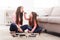 Mother and daughter doing makeup sitting on the floor