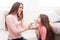 Mother and daughter doing makeup sitting on the floor