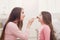 Mother and daughter doing makeup sitting on the floor