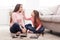 Mother and daughter doing makeup sitting on the floor