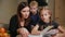 Mother and daughter doing a school homework assignment, a little boy watches it. Brother helps to do homework.