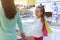 Mother and daughter doing shopping. Child holding shopping bags