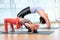 Mother and daughter doing yoga exercise at indoor studio together, sporty family practicing yoga standing together and doing Wheel