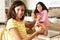 Mother and daughter eating cereal and fruit