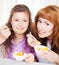 Mother and daughter eating cereal and fruit