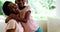 Mother and daughter embracing each other in living room