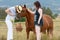 Mother & daughter enjoying day together feeding horses in country