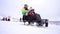 Mother and daughter enjoying a sleigh ride on a beautiful winter day. Smiling family sitting on the sled. Winter