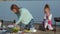 Mother and daughter fry meat and vegetables on a barbecue on the beach on the beach
