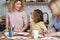 Mother with daughter and grandmother making Easter decorations at home