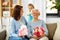 Mother and daughter greeting grandmother at home